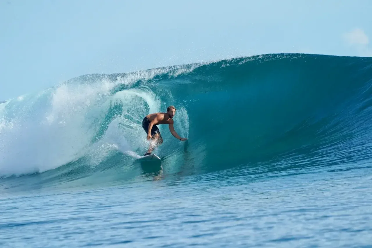 a man riding a wave on top of a surfboard