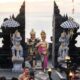 Balinese dancers perform at the iconic Uluwatu Temple during sunset, showcasing vibrant traditional attire.