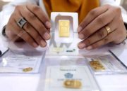 Kepingan emas batangan Antam dengan latar belakang putih