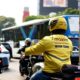 Seorang pengemudi ojek online Maxim sedang melayani penumpang di jalan raya Jakarta.