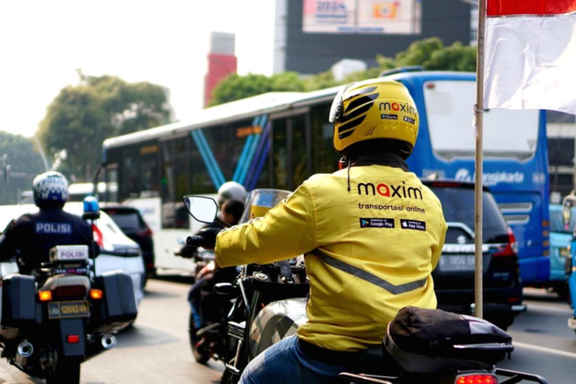 Seorang pengemudi ojek online Maxim sedang melayani penumpang di jalan raya Jakarta.