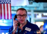 Tampilan papan perdagangan saham digital dengan grafik hijau di bursa Wall Street, New York.