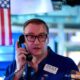 Papan layar elektronik yang menampilkan pergerakan indeks saham di bursa Wall Street, New York.