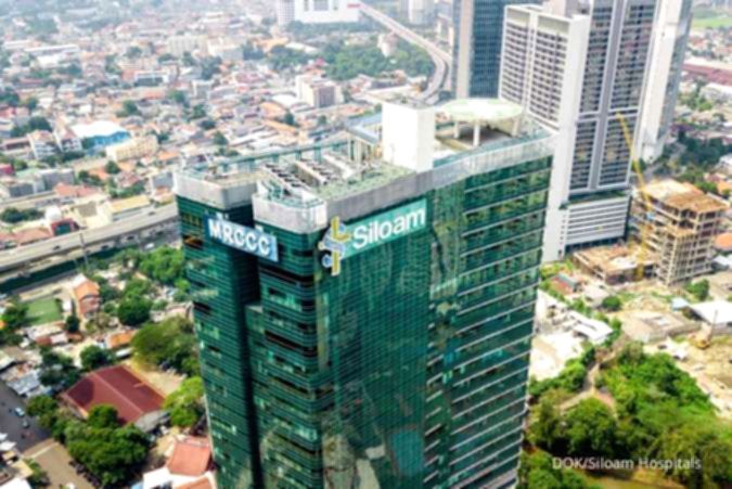 Gedung rumah sakit Siloam Hospitals dengan logo perusahaan yang terlihat jelas di area perkotaan