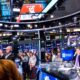 Layar monitor menampilkan grafik pergerakan indeks saham Wall Street yang sedang menguat