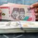 Grafik pergerakan nilai tukar mata uang Rupiah terhadap Dolar AS di layar monitor.