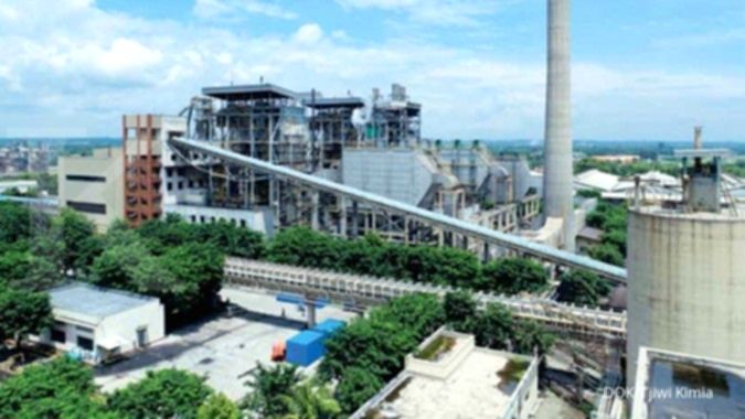 Tumpukan gulungan kertas besar di fasilitas produksi pabrik kertas industri.