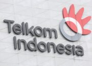 Logo PT Telkom Indonesia dengan latar belakang gedung perkantoran