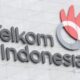 Logo PT Telkom Indonesia dengan latar belakang gedung perkantoran