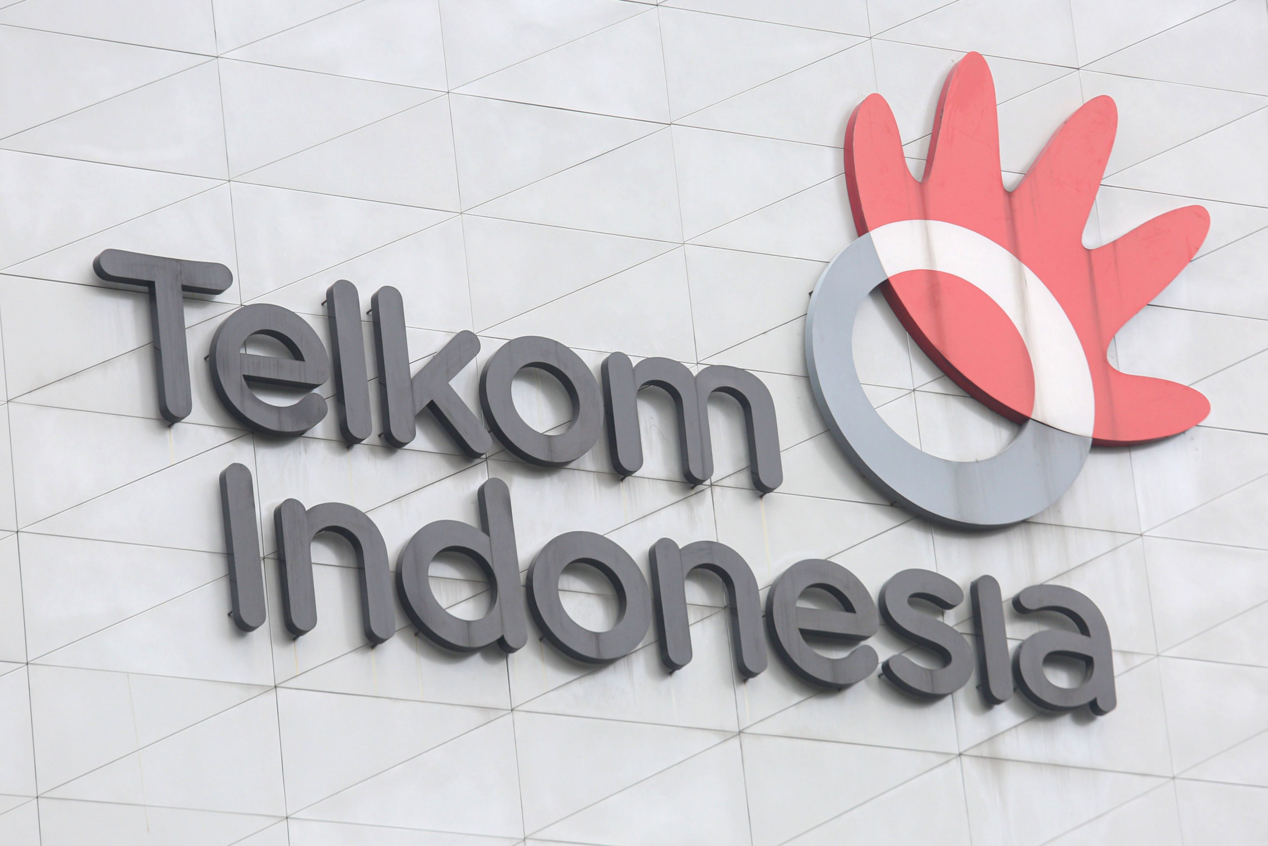 Logo PT Telkom Indonesia dengan latar belakang gedung perkantoran