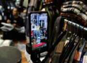 Tampilan antarmuka aplikasi TikTok Shop di layar ponsel pintar dengan latar belakang grafik pertumbuhan ekonomi
