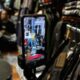 Tampilan antarmuka aplikasi TikTok Shop di layar ponsel pintar dengan latar belakang grafik pertumbuhan ekonomi